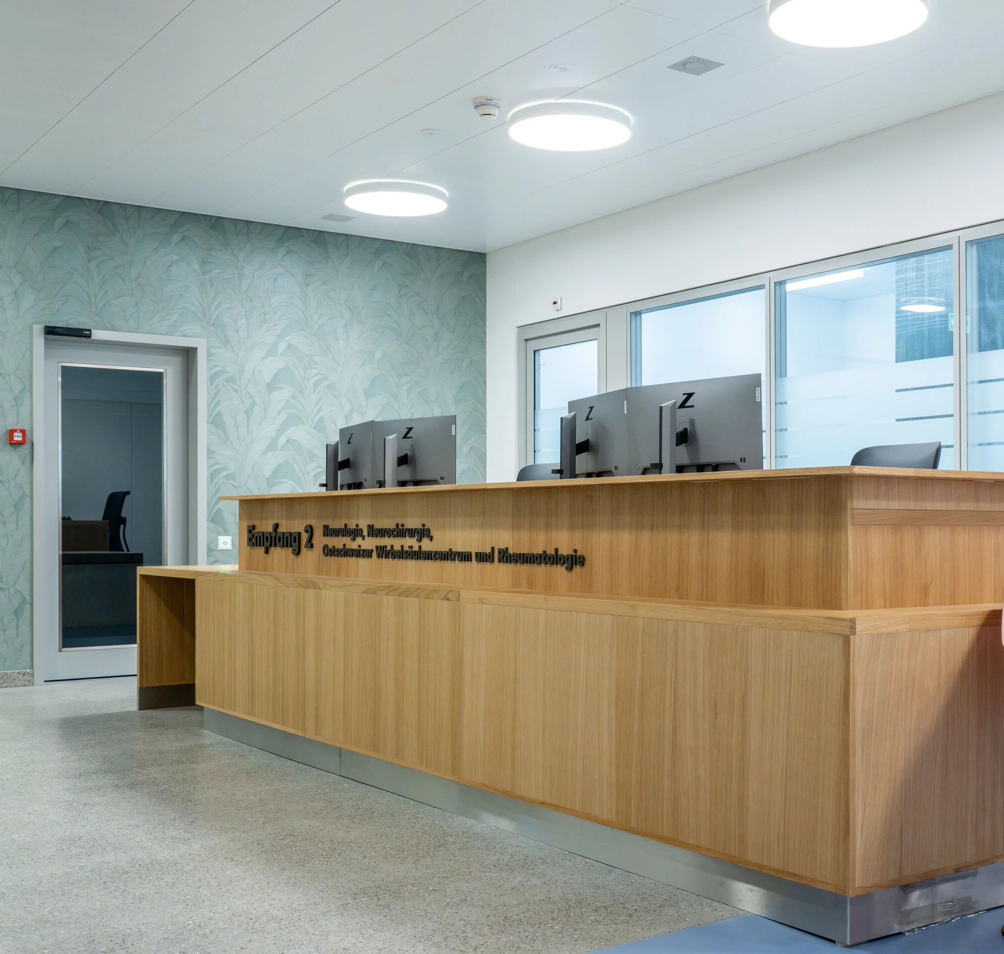 Heller Empfangsbereich einer Gesundheitseinrichtung mit moderner, blendfreier Tulux LED-Beleuchtung für eine angenehme Orientierung und Atmosphäre