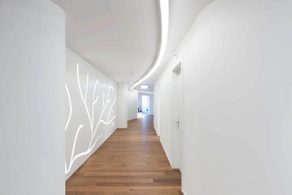 Heller Empfangsbereich einer Gesundheitseinrichtung mit moderner, blendfreier LED-Beleuchtung für eine angenehme Orientierung und Atmosphäre.